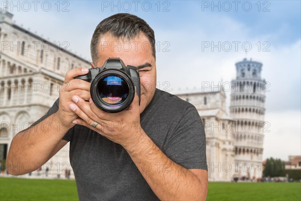 Hispanic male photographer with camera at leaning tower of pisa