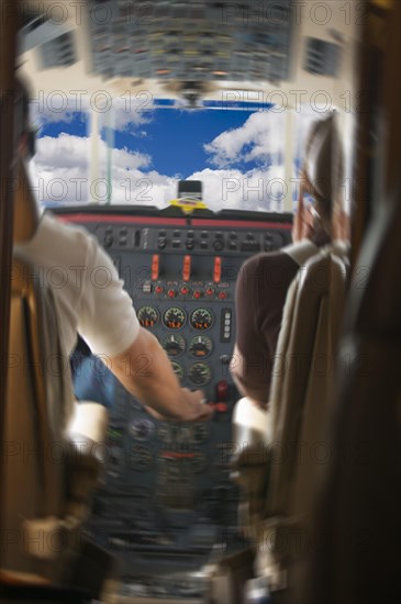 Jet cockpit with pilots and clouds