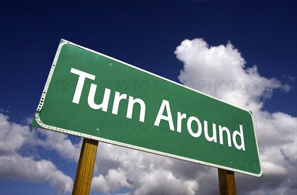 Turn around road sign with dramatic clouds and sky