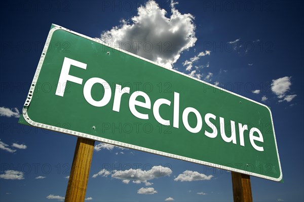 Foreclosure green road sign with dramatic clouds and sky