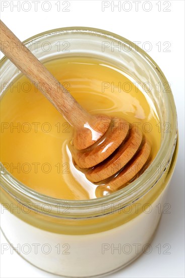 Cremiger Bienenhonig in Glas und Honigloeffel