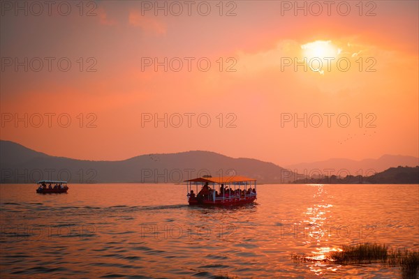 Tourist boat in lake Pichola on sunset. Udaipur