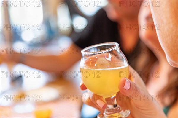 Female hand holding glass of micro brew beer at bar