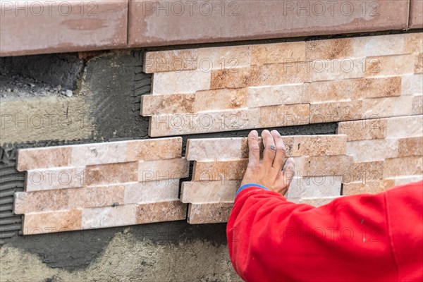 Worker installing wall tile at construction site