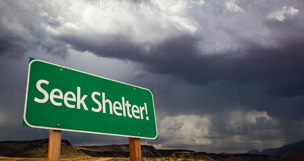 Seek shelter green road sign with dramatic clouds and rain