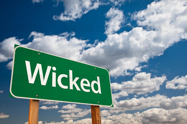 Wicked green road sign with dramatic clouds and sky