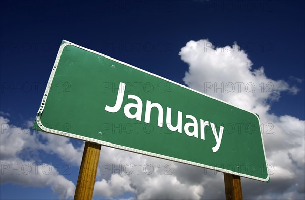 January green road sign with dramatic blue sky and clouds