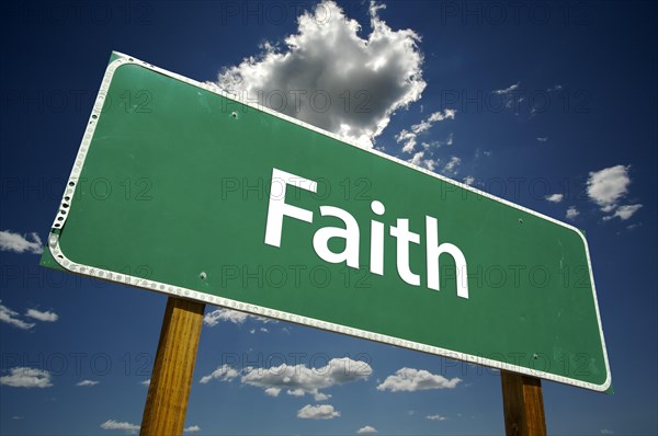 Faith road sign with dramatic clouds and sky