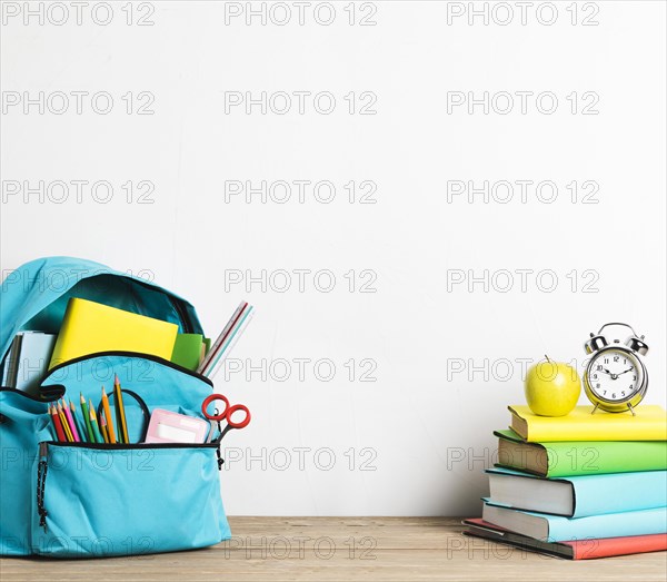 Alarm clock stack books well packed school bag with supplies