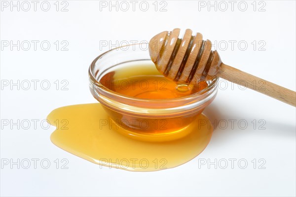 Bee honey with honey spoon in bowl