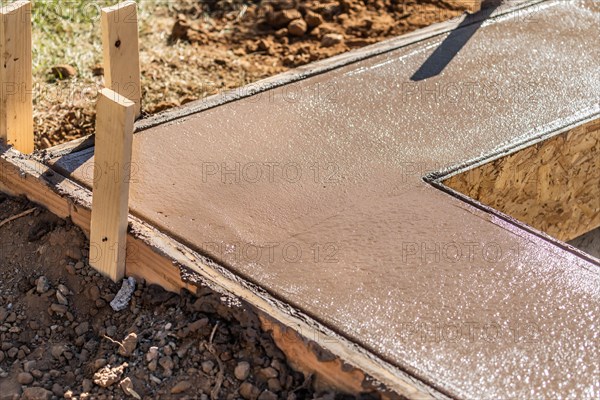 Fresh pool coping cement drying within wood framing