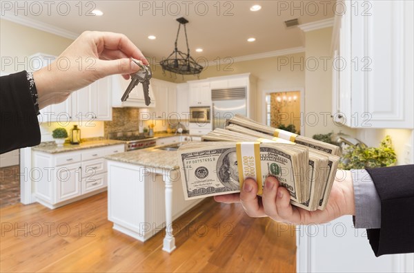 Handing over keys for cash in beautiful custom kitchen interior