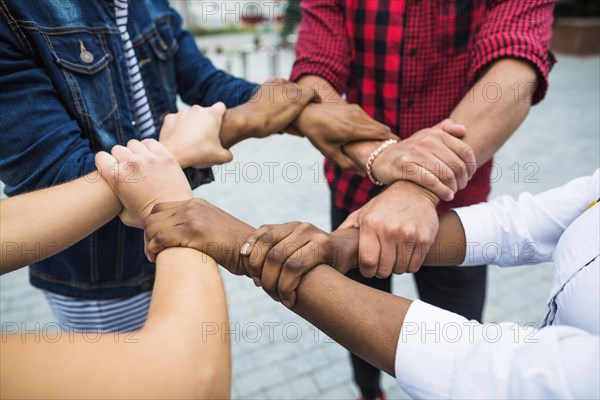 Anonymous multiracial people stacking hands