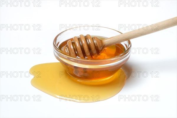 Bee honey with honey spoon in bowl