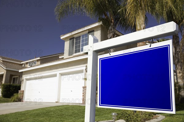 Blank real estate sign in front of house