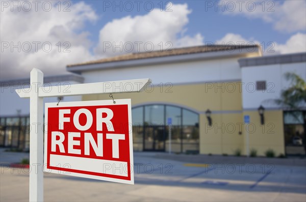 Vacant retail building with for rent real estate sign in front