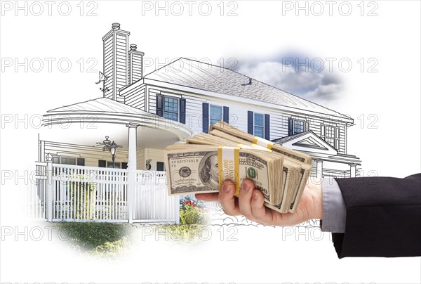 Hand holding thousands of dollars in cash over house drawing and photo area