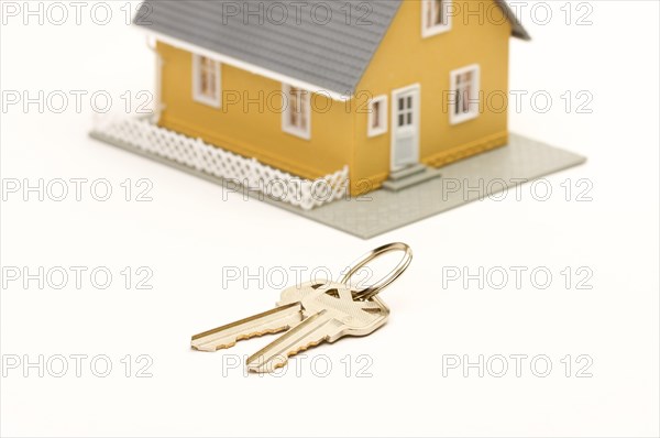 Keys and house isolated on a white background. focus is on the keys