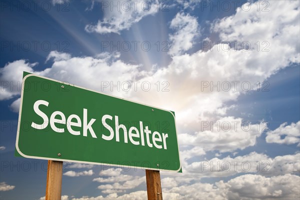 Seek shelter green road sign with dramatic clouds and sky