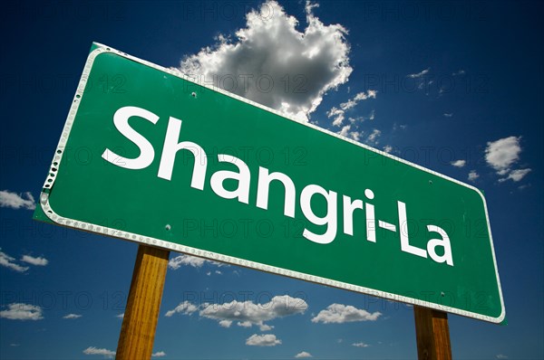 Shangri-La green road sign with dramatic clouds and sky