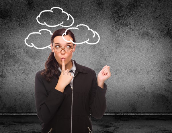 Clouds drawn around head of young adult woman in front of wall with copy space