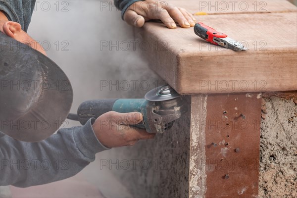 Construction worker using grinder at construction site