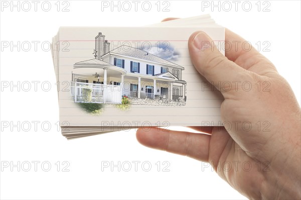 Male hand holding stack of flash cards with house drawing isolated on a white background