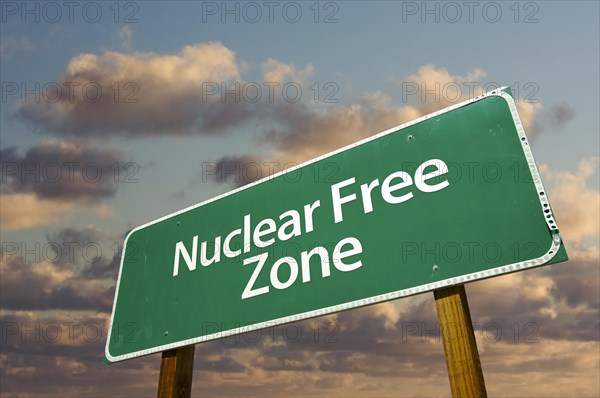 Nuclear free green road sign in front of dramatic clouds and sky