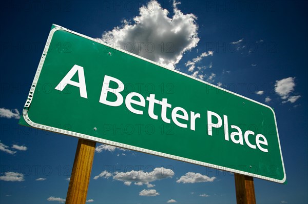 A better place green road sign over dramatic sky and clouds