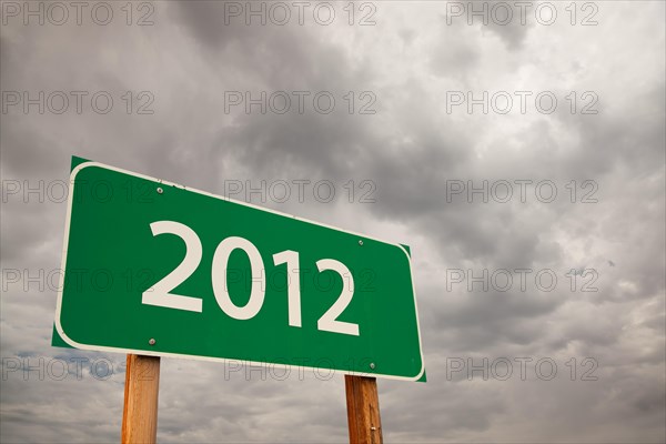 2012 green road sign with dramatic storm clouds and sky