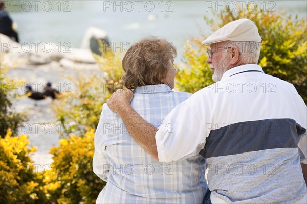 Happy senior couple on a bench enjoying each other in the park