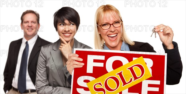 Real estate team behind with blonde woman in front holding keys and sold for sale real estate sign isolated on a white background