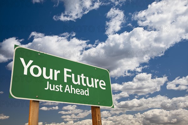 Your future green road sign over dramatic clouds and sky