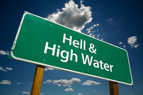 Hell and high water green road sign with dramatic clouds and sky