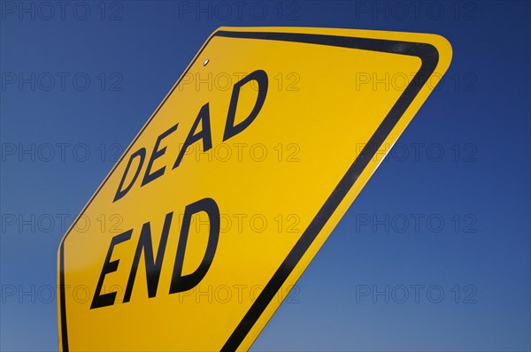 Dead end traffic sign against deep blue sky