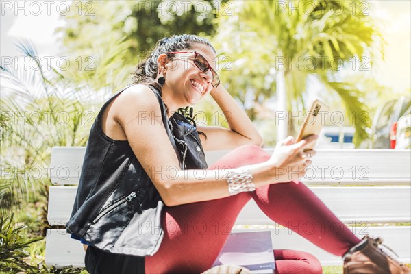 Girl sitting on a bench checking her cell phone