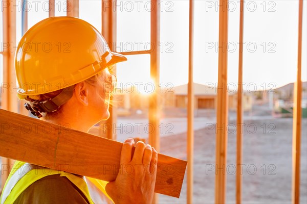 Female construcion worker looking out from new home framing