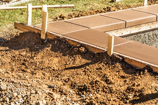 Fresh pool coping cement drying within wood framing