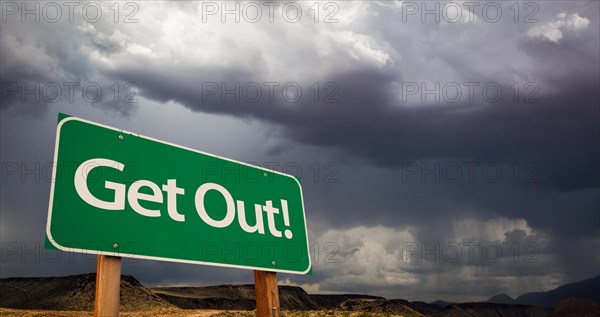 Get out green road sign with dramatic clouds and rain