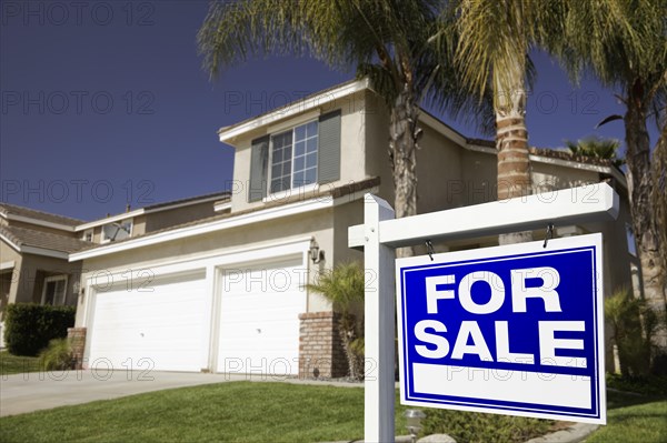 Blue for sale real estate sign in front of house