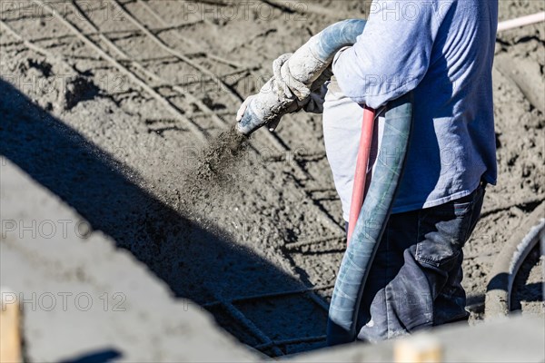 Pool construction worker shooting concrete