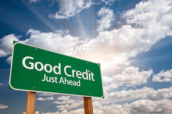 Good credit green road sign with dramatic clouds