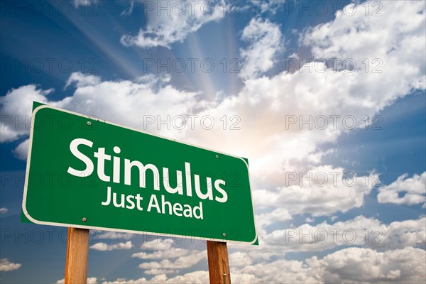 Stimulus green road sign with dramatic clouds