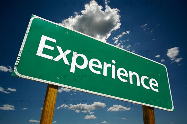 Experience road sign with dramatic clouds and sky