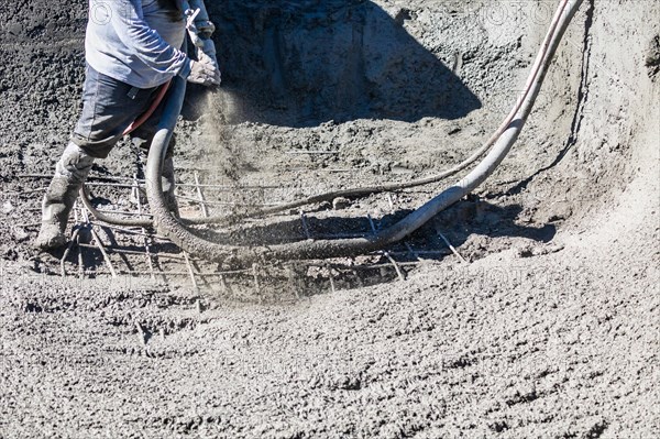 Pool construction worker shooting concrete