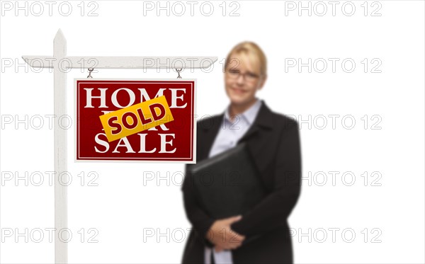 Businesswoman behind sold home for sale real estate sign isolated on a white background
