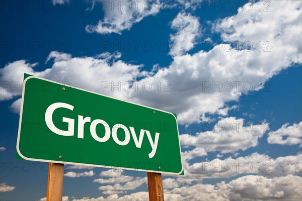 Groovy green road sign with dramatic clouds and sky