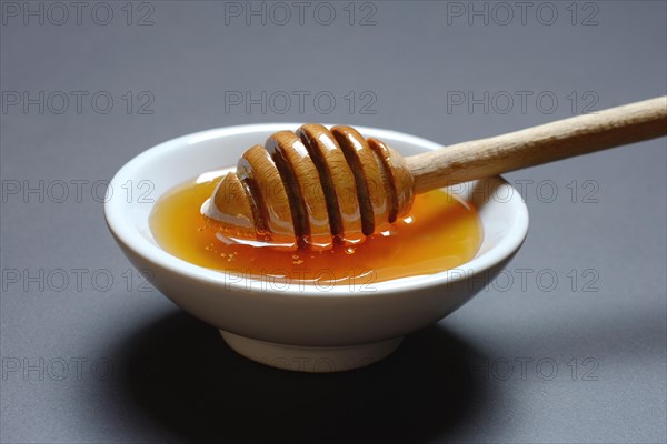 Bee honey with honey spoon in bowl