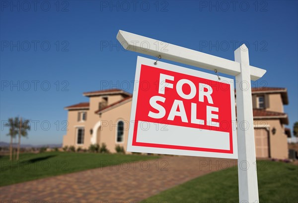 Home for sale sign in front of new house