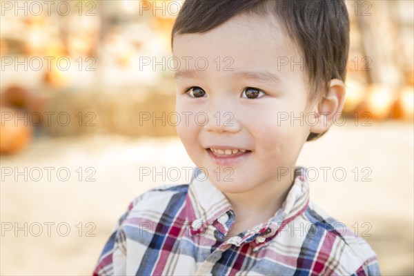 Cute mixed-race young boy having fun at the pumpkin patch